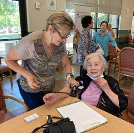 Female volunteer helping older woman with tablet